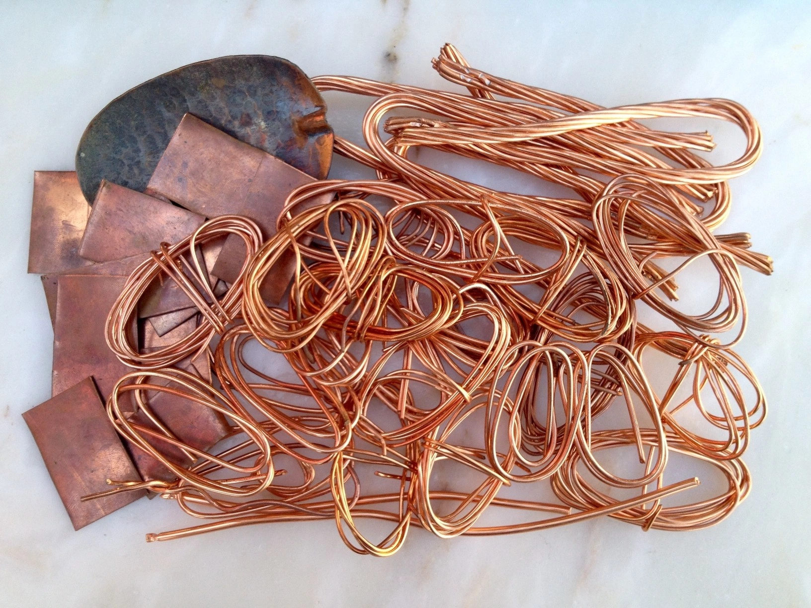 Pile of bright copper wire and copper sheet scrap ready for recycling